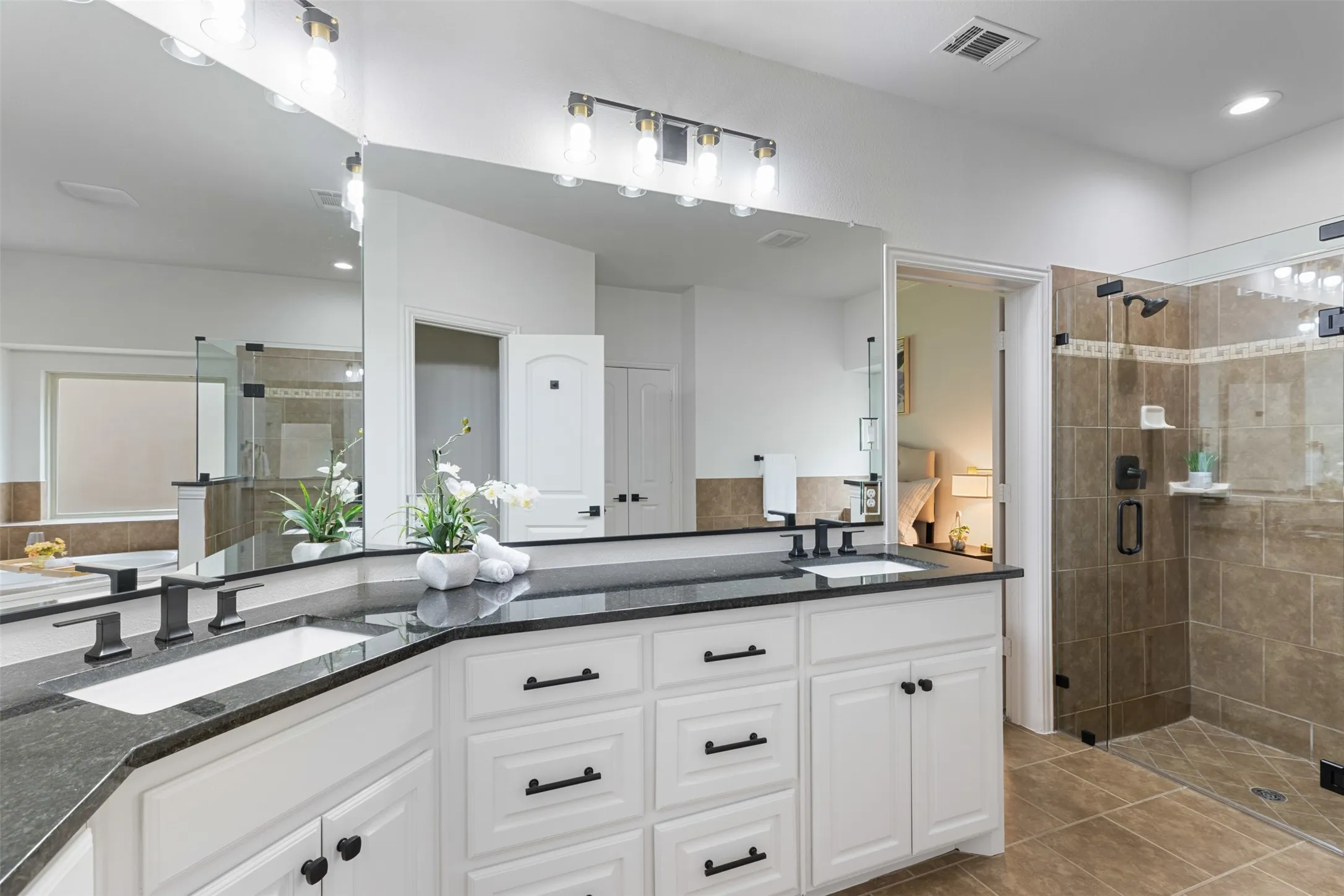 Full bath featuring a sink, a shower stall, tile patterned floors, and visible vents