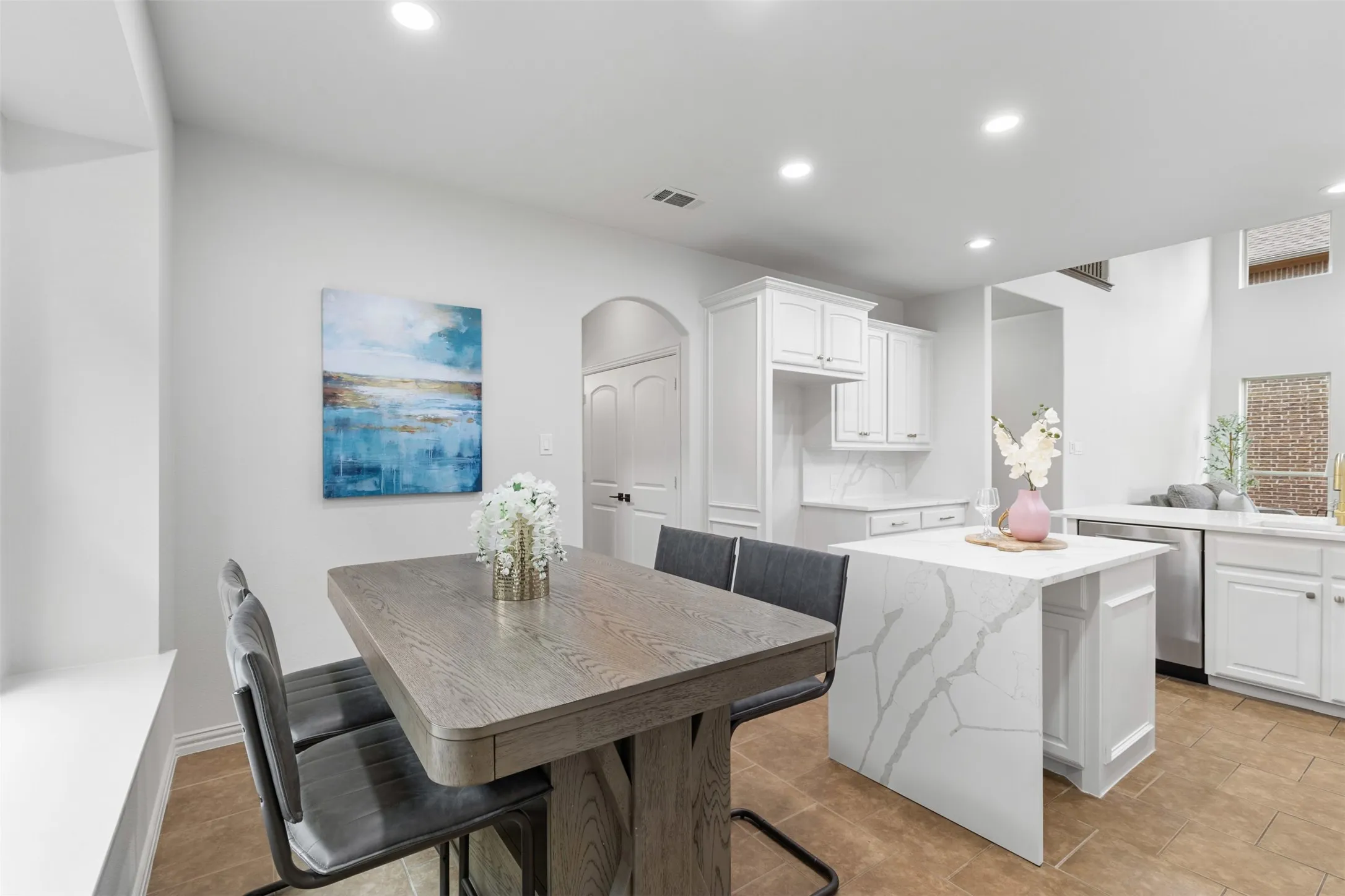 Kitchen featuring dishwasher, white cabinets, recessed lighting, and a center island