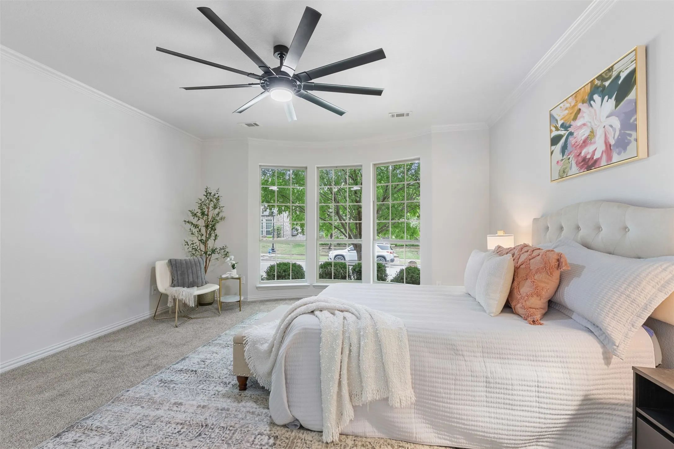 Carpeted bedroom featuring ornamental molding, a ceiling fan, visible vents, and baseboards