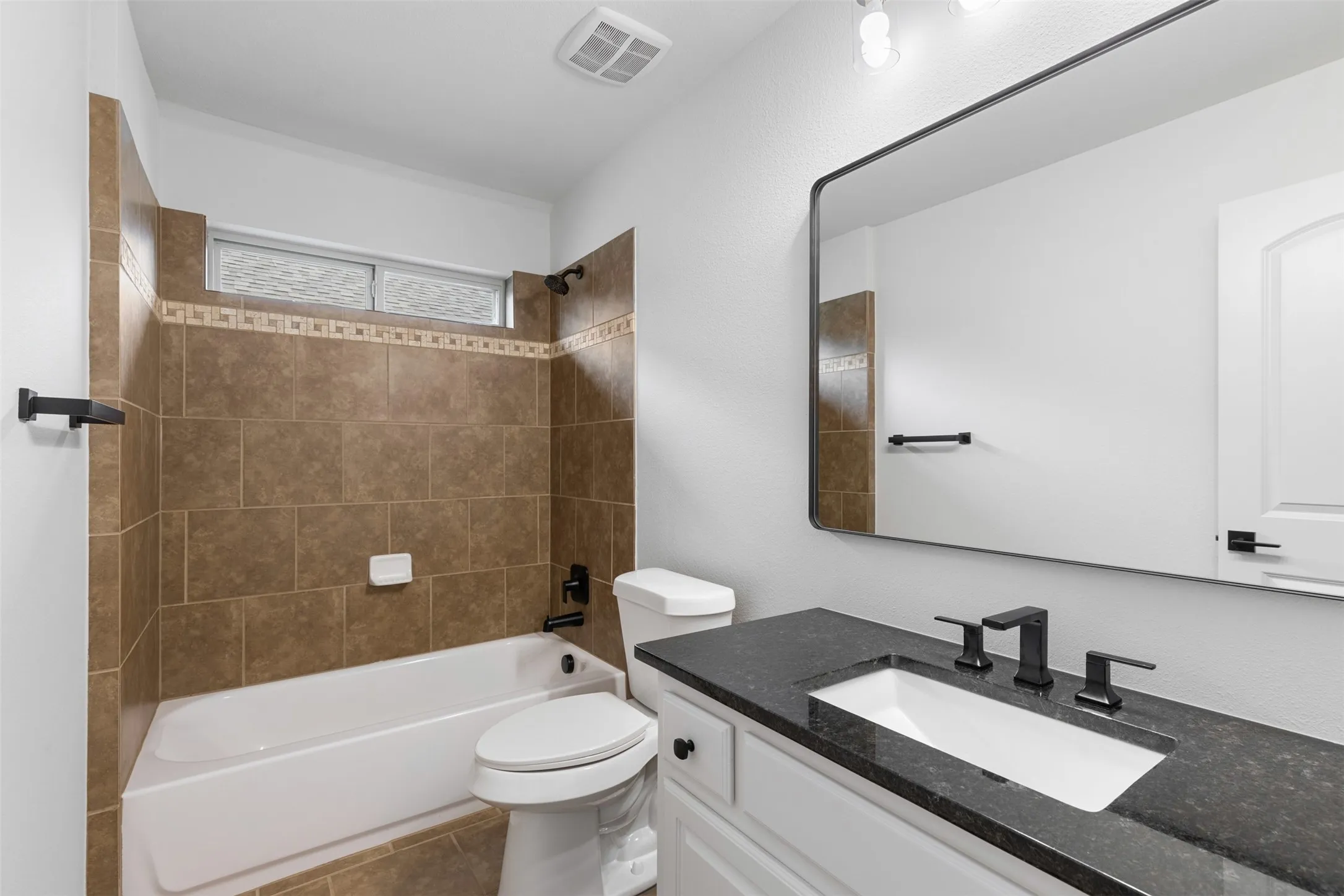 Full bath featuring vanity, toilet, visible vents, bathtub / shower combination, and tile patterned flooring