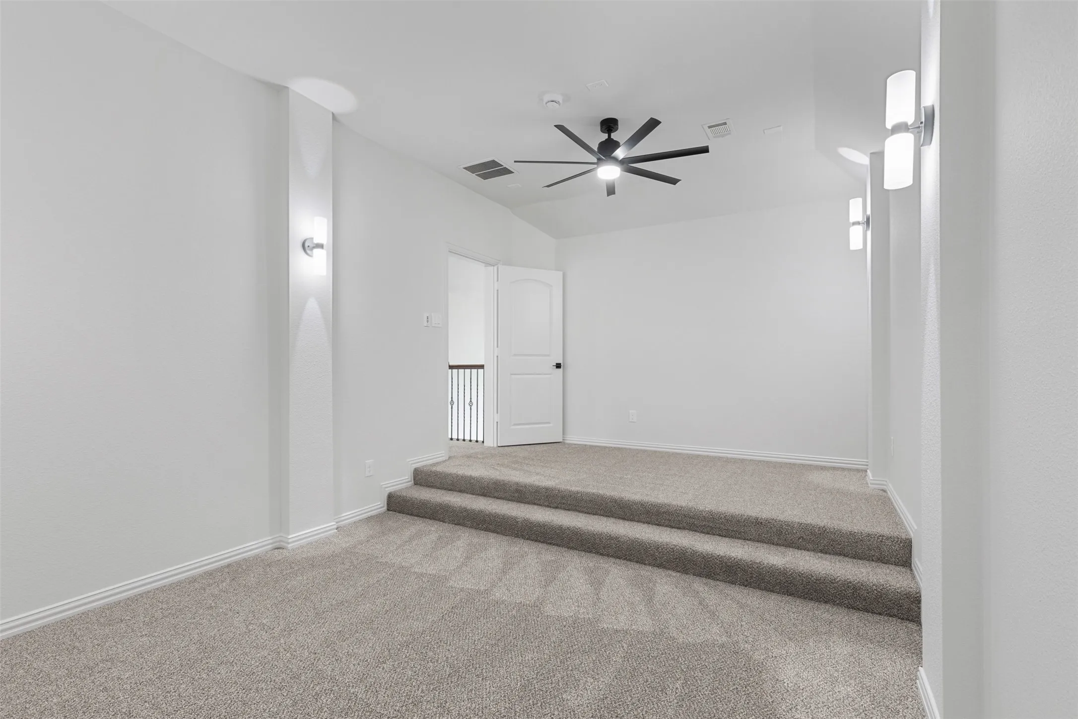 Carpeted empty room featuring visible vents, a ceiling fan, and baseboards