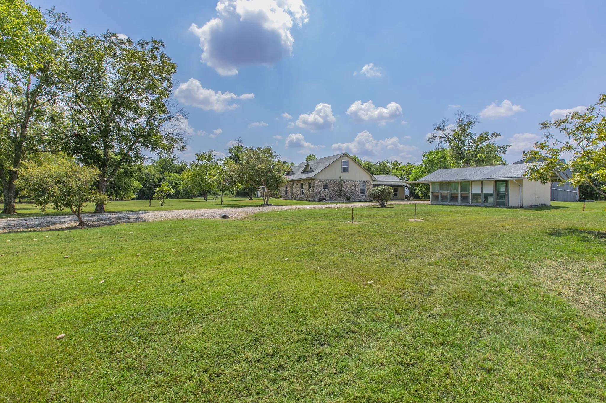 View of grassy yard with a sunroom