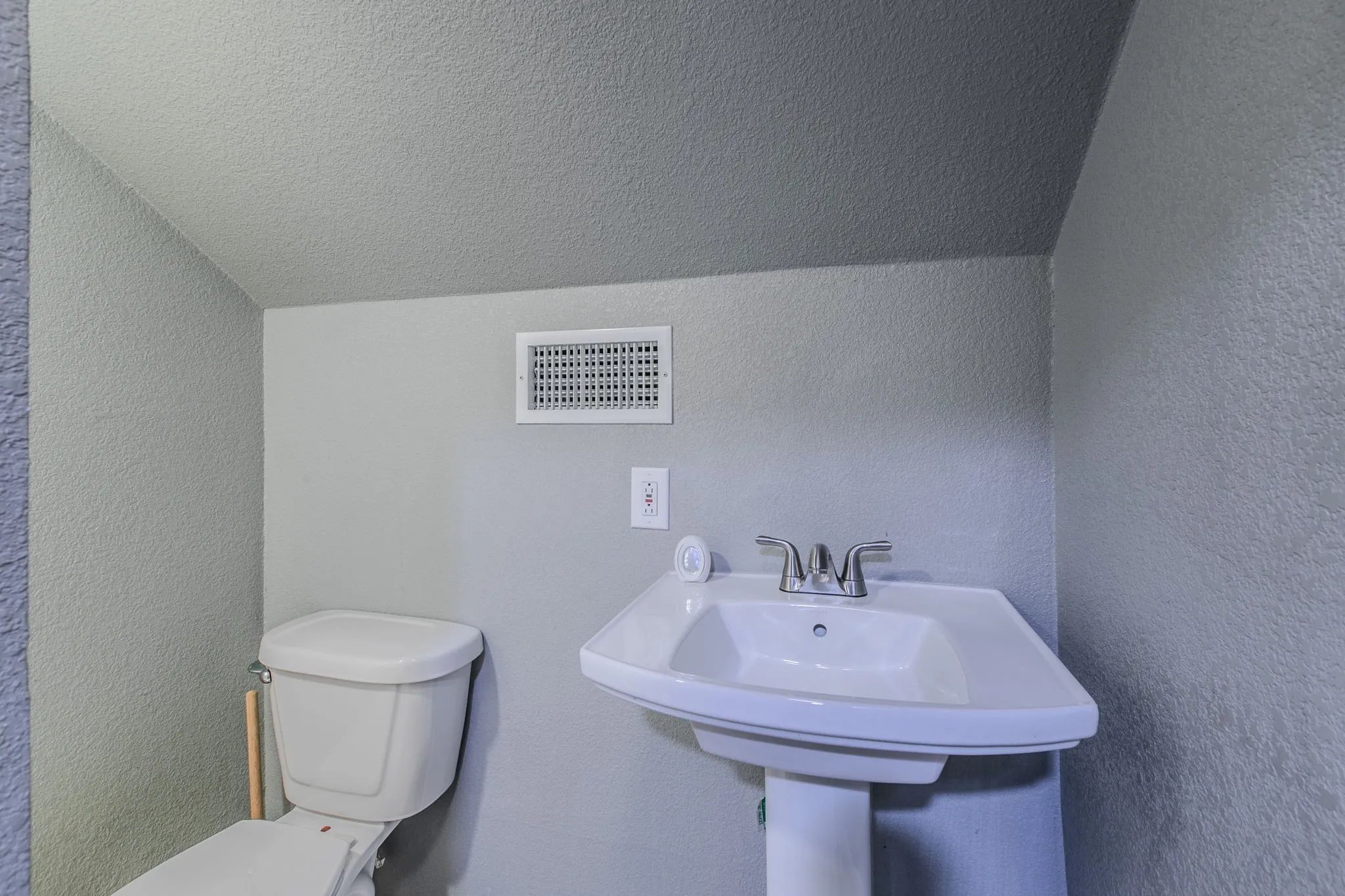 Half bathroom with a textured wall and a textured ceiling