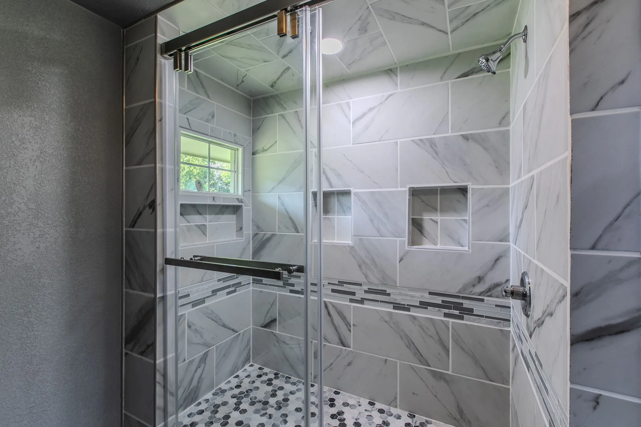 Full bath featuring a stall shower and a textured wall