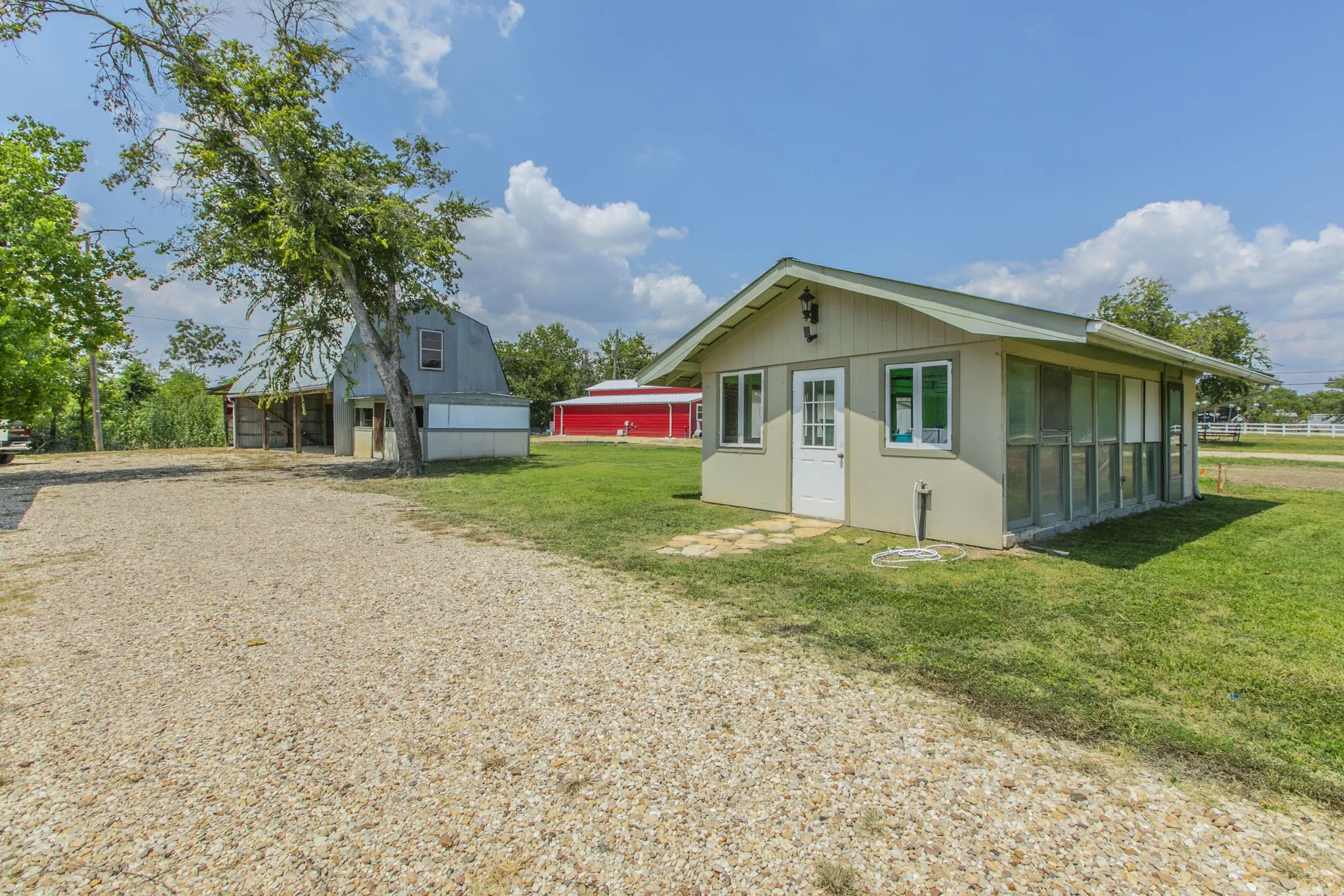 View of property exterior featuring an outbuilding, a yard, and driveway