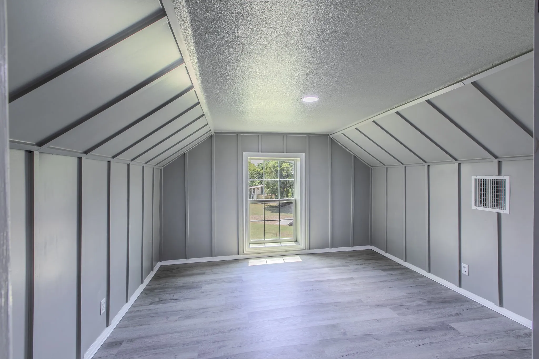 Additional living space featuring a textured ceiling, lofted ceiling, and light wood finished floors