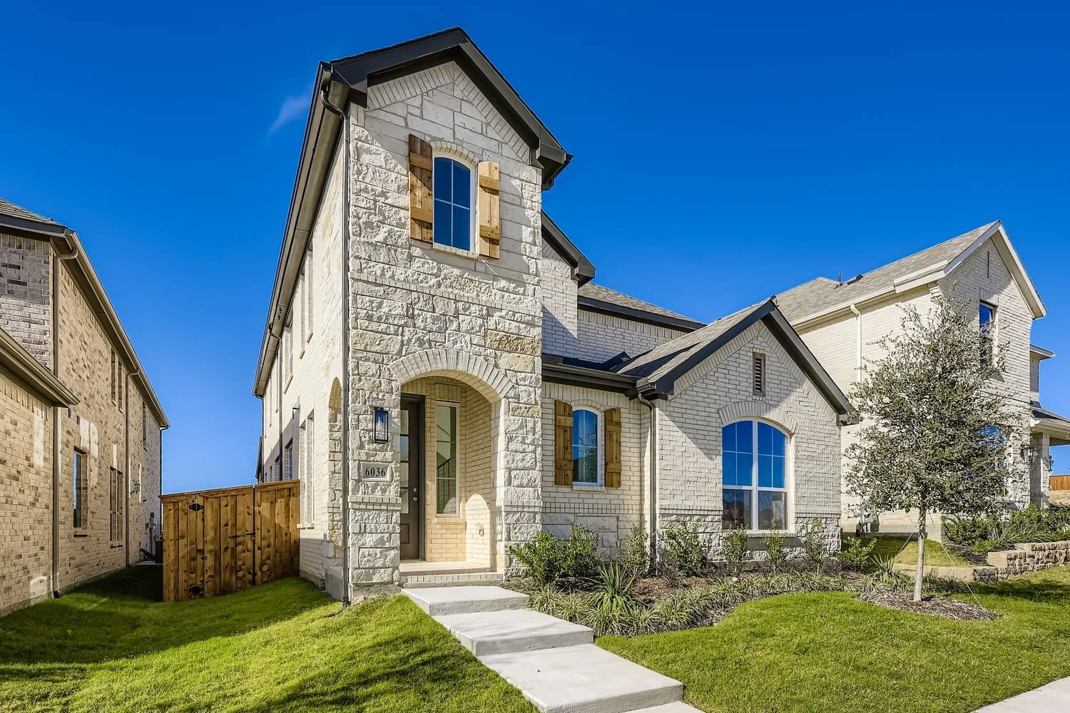 French provincial home featuring stone siding and brick siding
