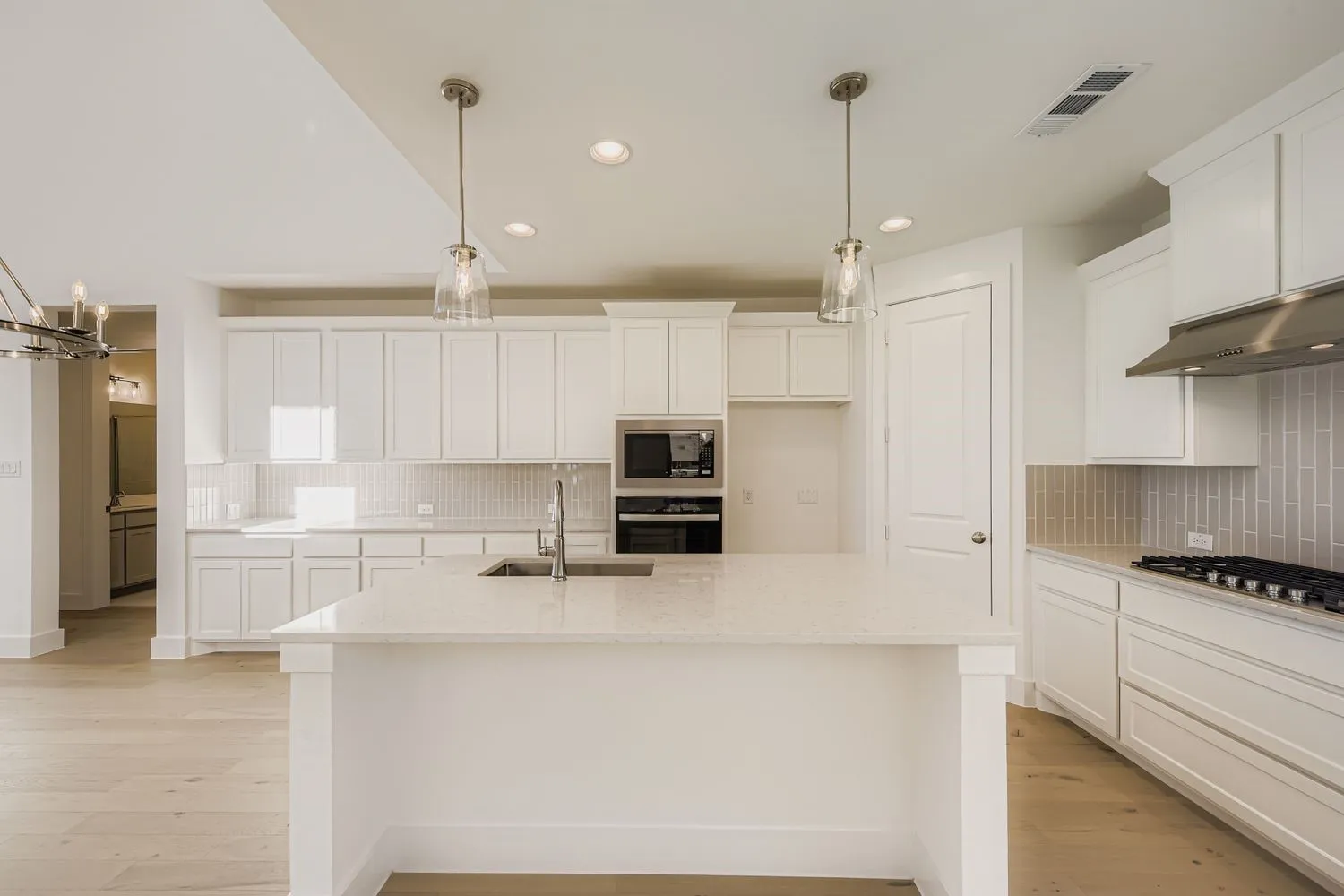 Kitchen featuring backsplash, pendant lighting, white cabinetry, and recessed lighting