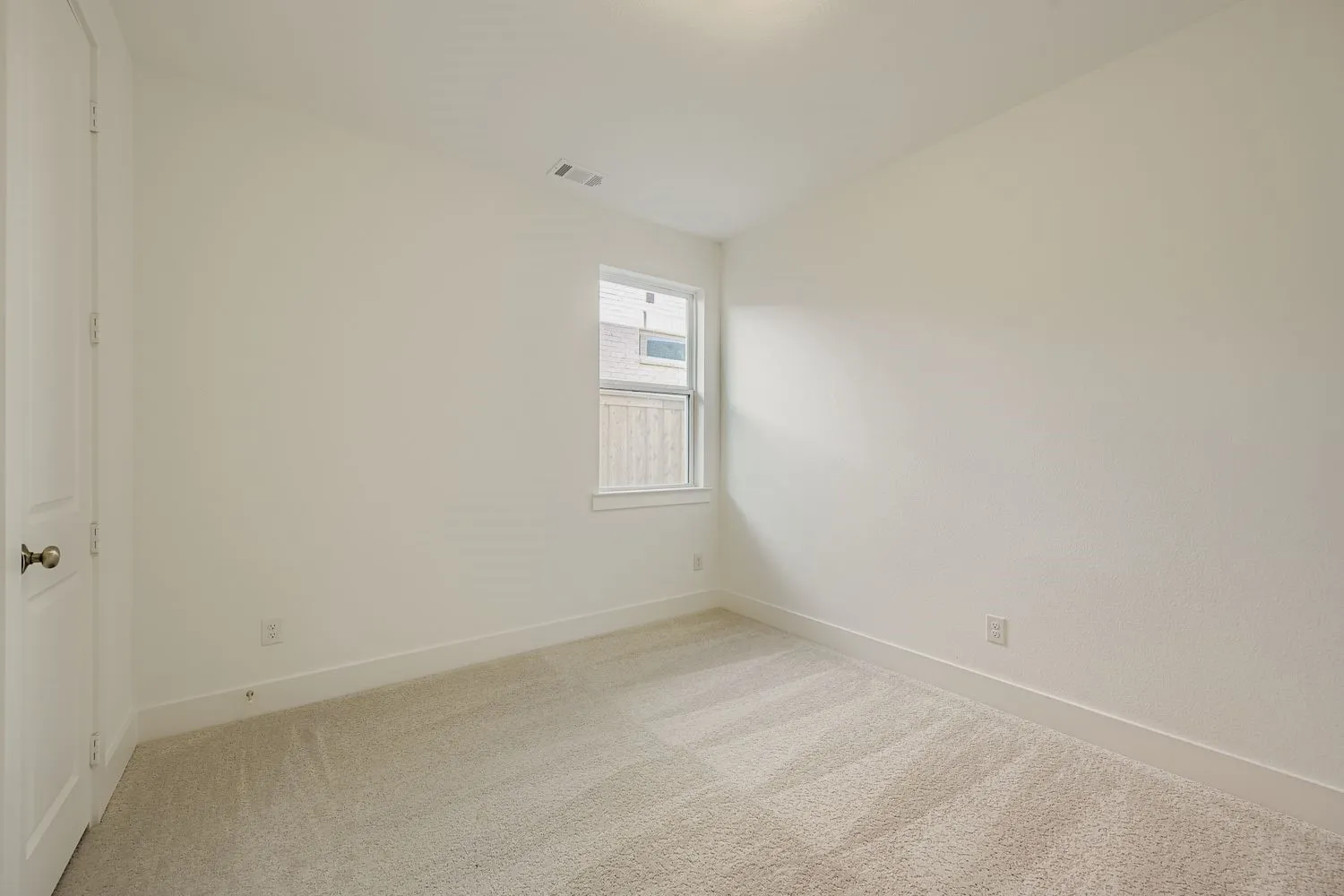 Carpeted empty room featuring baseboards
