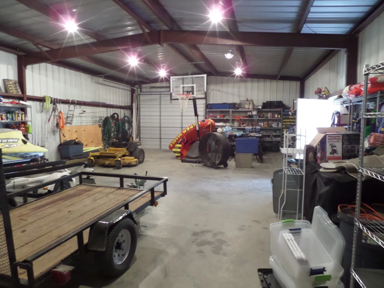 Garage featuring metal wall, a workshop area, and freestanding refrigerator
