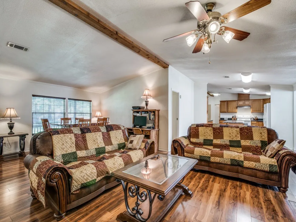 Living room with wood finished floors, ceiling fan, and a textured ceiling