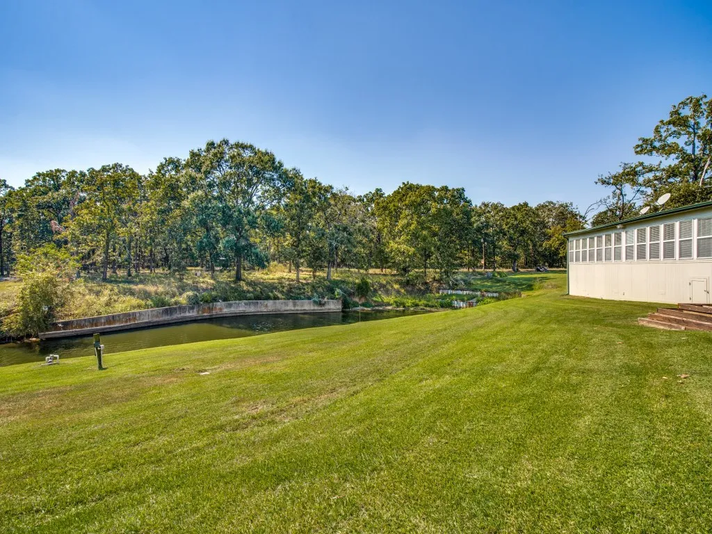 View of green lawn featuring a water view
