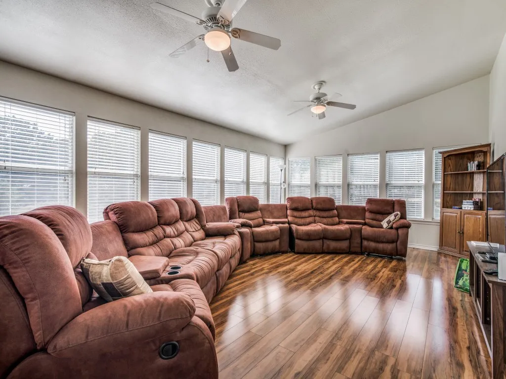 Living area featuring lofted ceiling, wood finished floors, and ceiling fan