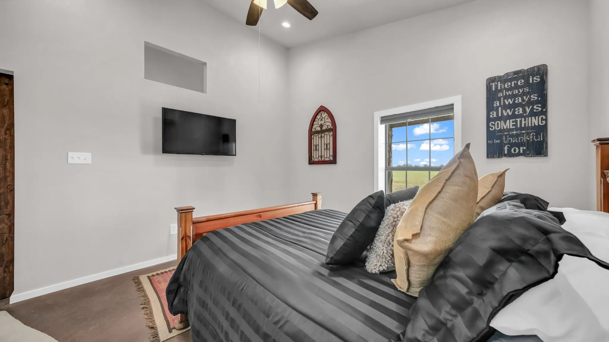 Bedroom with finished concrete floors, ceiling fan, and recessed lighting