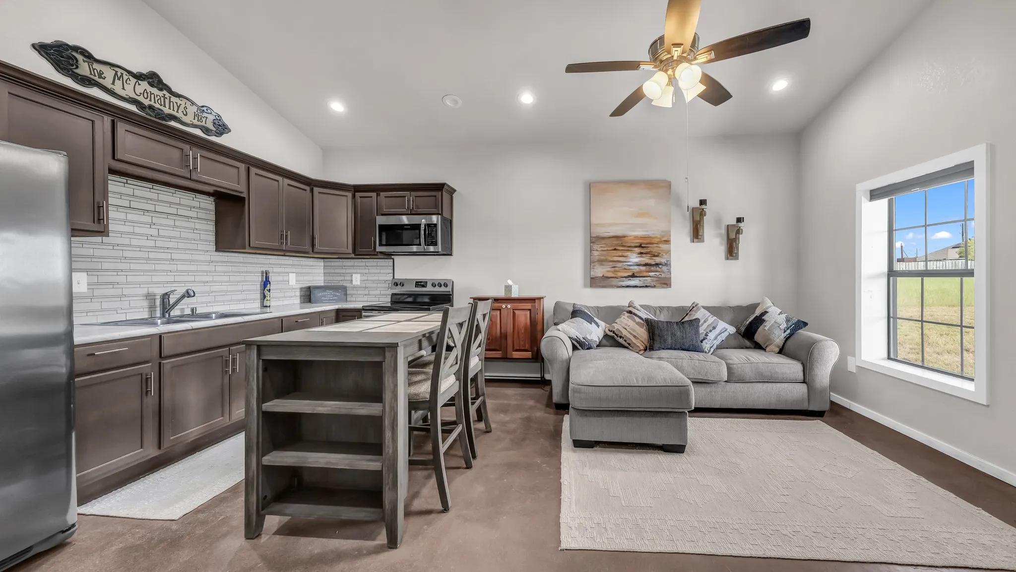Kitchen featuring dark brown cabinetry, decorative backsplash, stainless steel appliances, light countertops, and recessed lighting