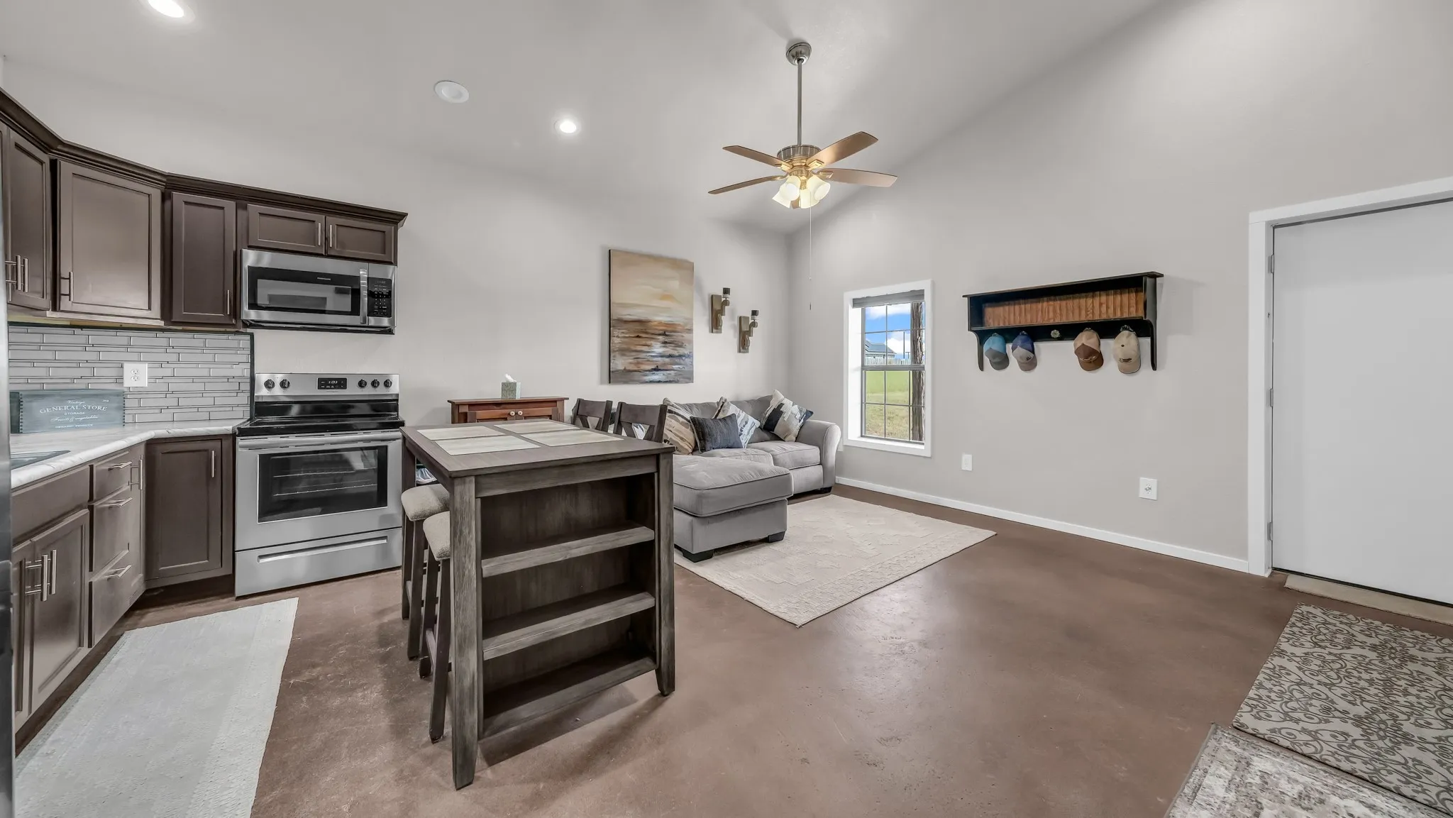 Kitchen featuring stainless steel appliances, dark brown cabinetry, tasteful backsplash, concrete flooring, and recessed lighting