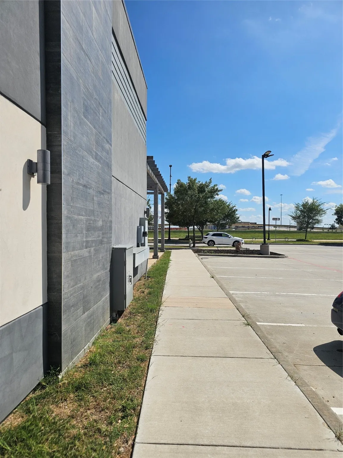 View of concrete road featuring sidewalks, street lighting, and curbs