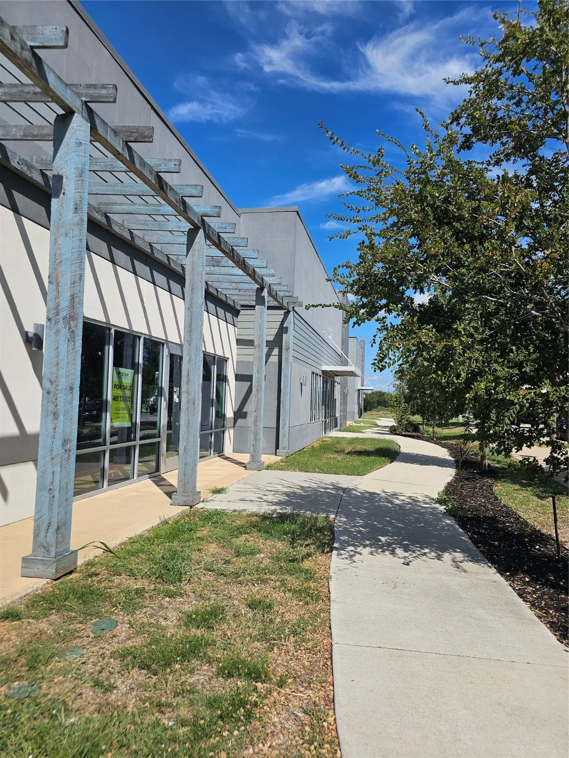 View of side of property with a pergola, a patio area, and a lawn