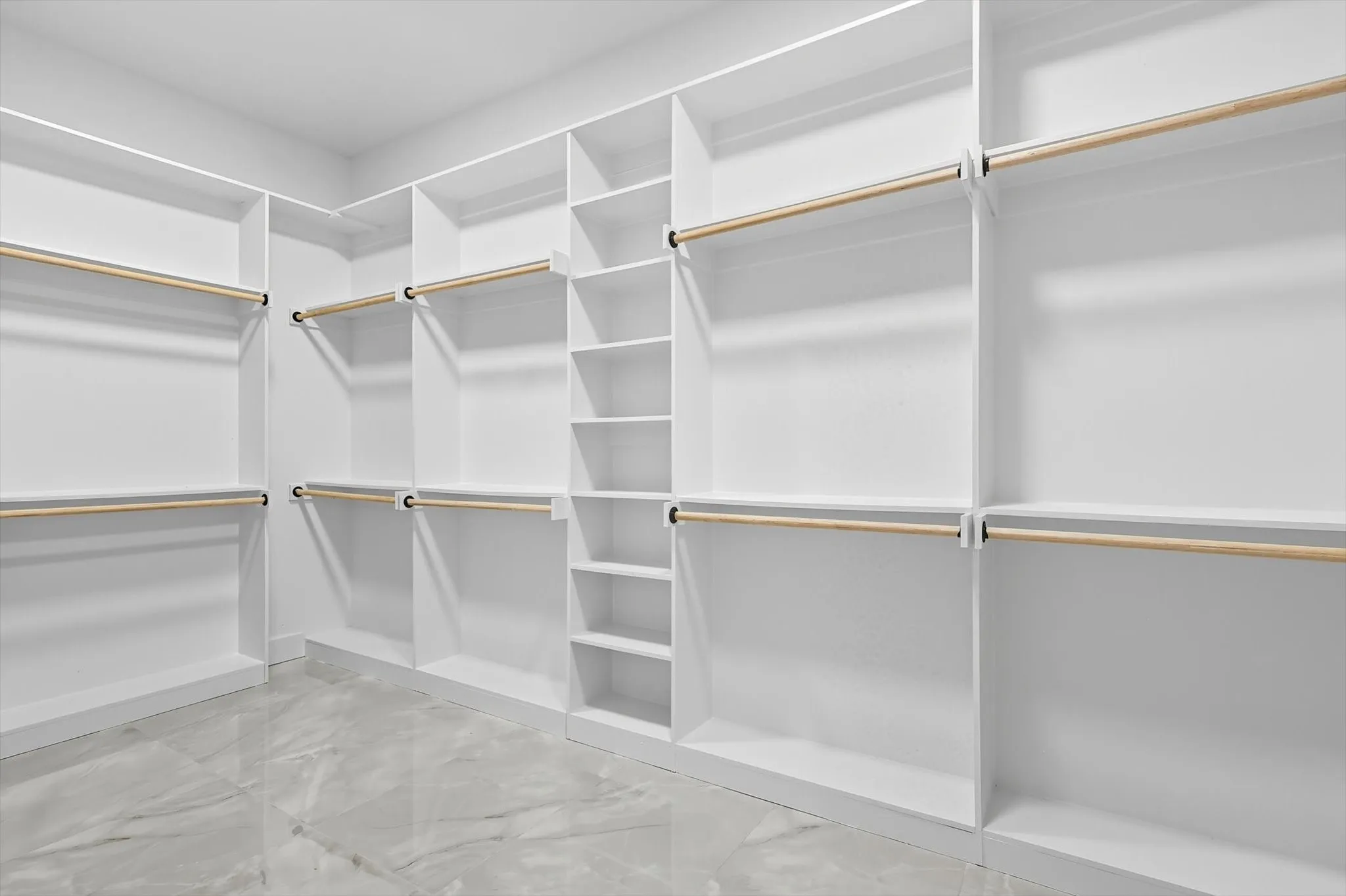 Spacious closet featuring light marble finish floors