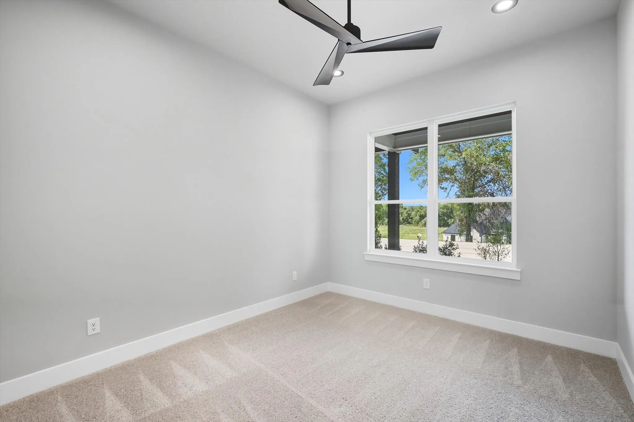 Empty room with light colored carpet, ceiling fan, and recessed lighting