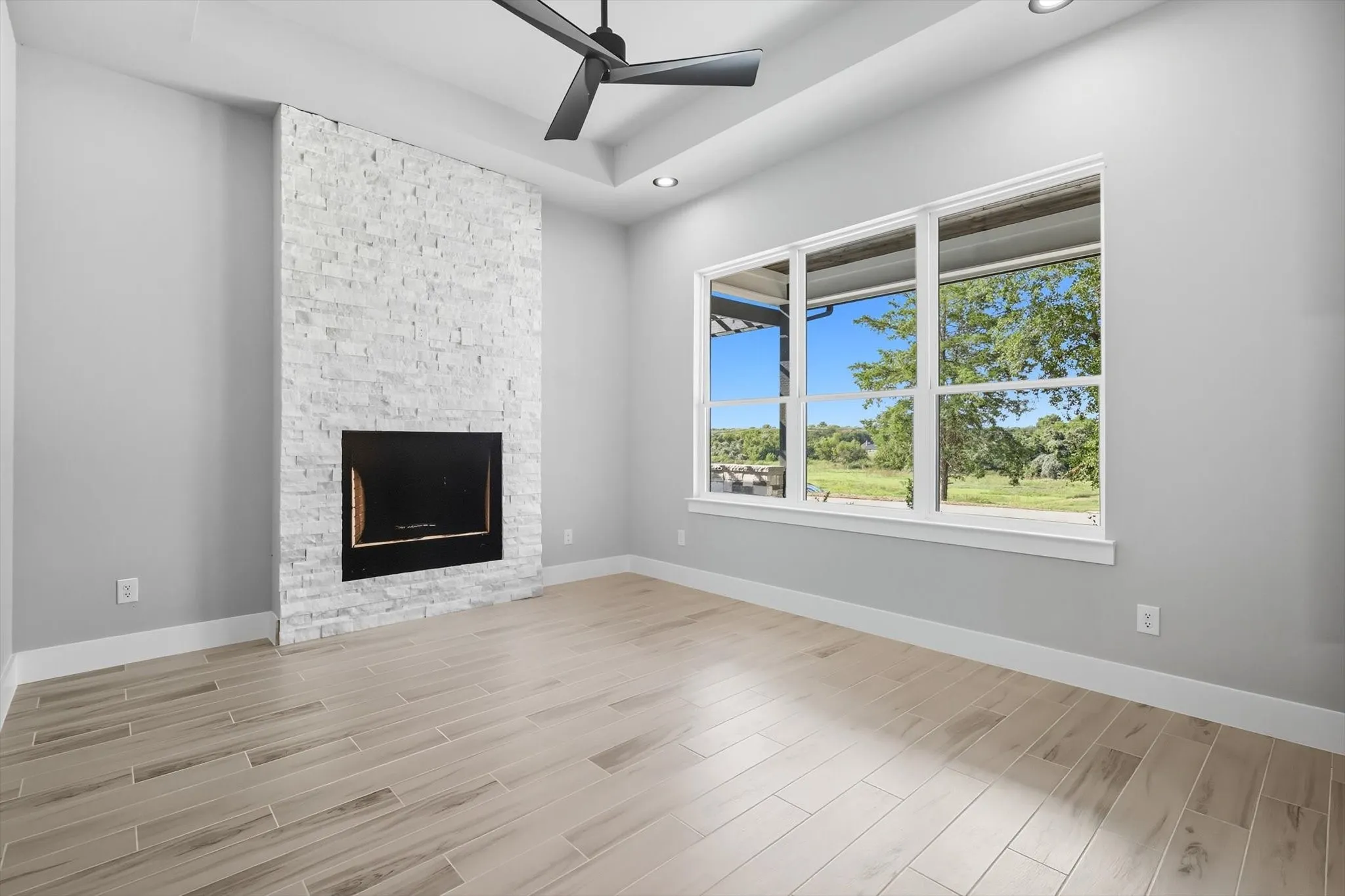 Unfurnished living room with a fireplace, wood finish floors, ceiling fan, and recessed lighting