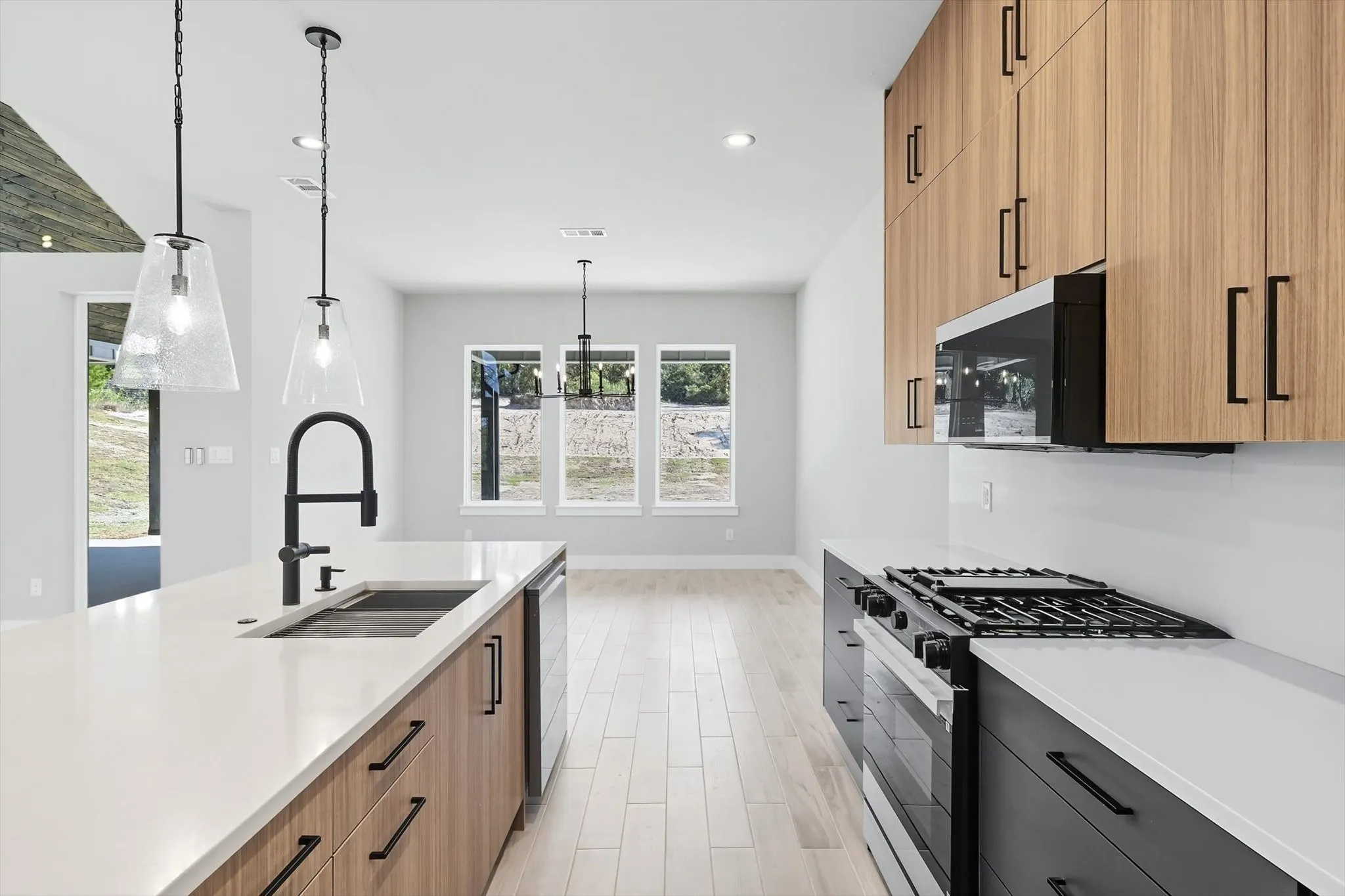 Kitchen with gas range, modern cabinets, pendant lighting, light wood-type flooring, and recessed lighting