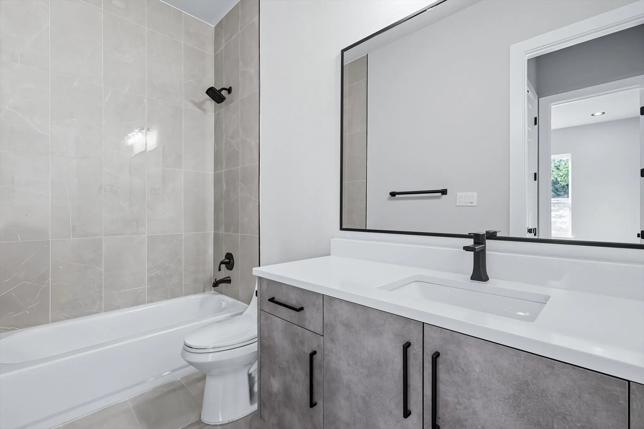 Bathroom featuring vanity, washtub / shower combination, and tile patterned flooring
