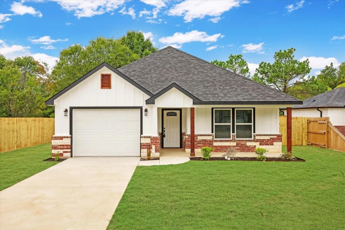 View of front facade with a porch, a shingled roof, brick siding, and concrete driveway