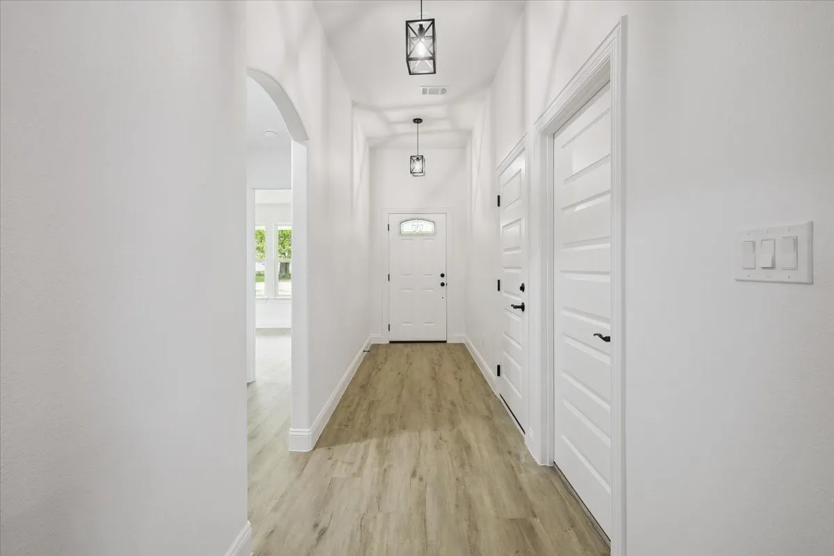 Entryway featuring arched walkways and wood finished floors