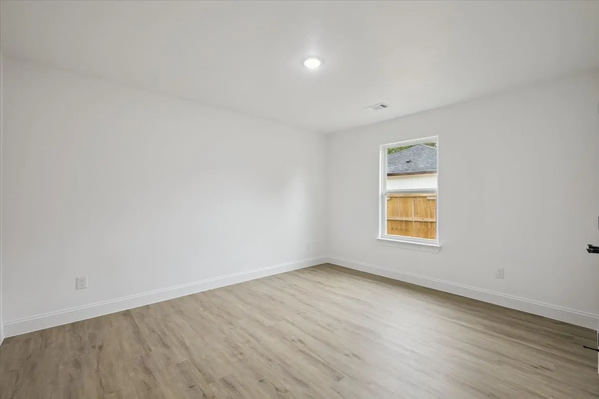 Spare room featuring light wood-style floors and baseboards
