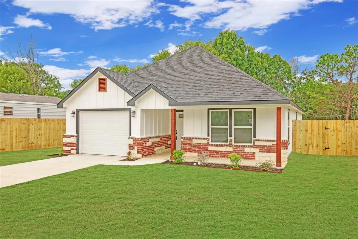 View of front of house featuring brick siding, a porch, roof with shingles, and board and batten siding