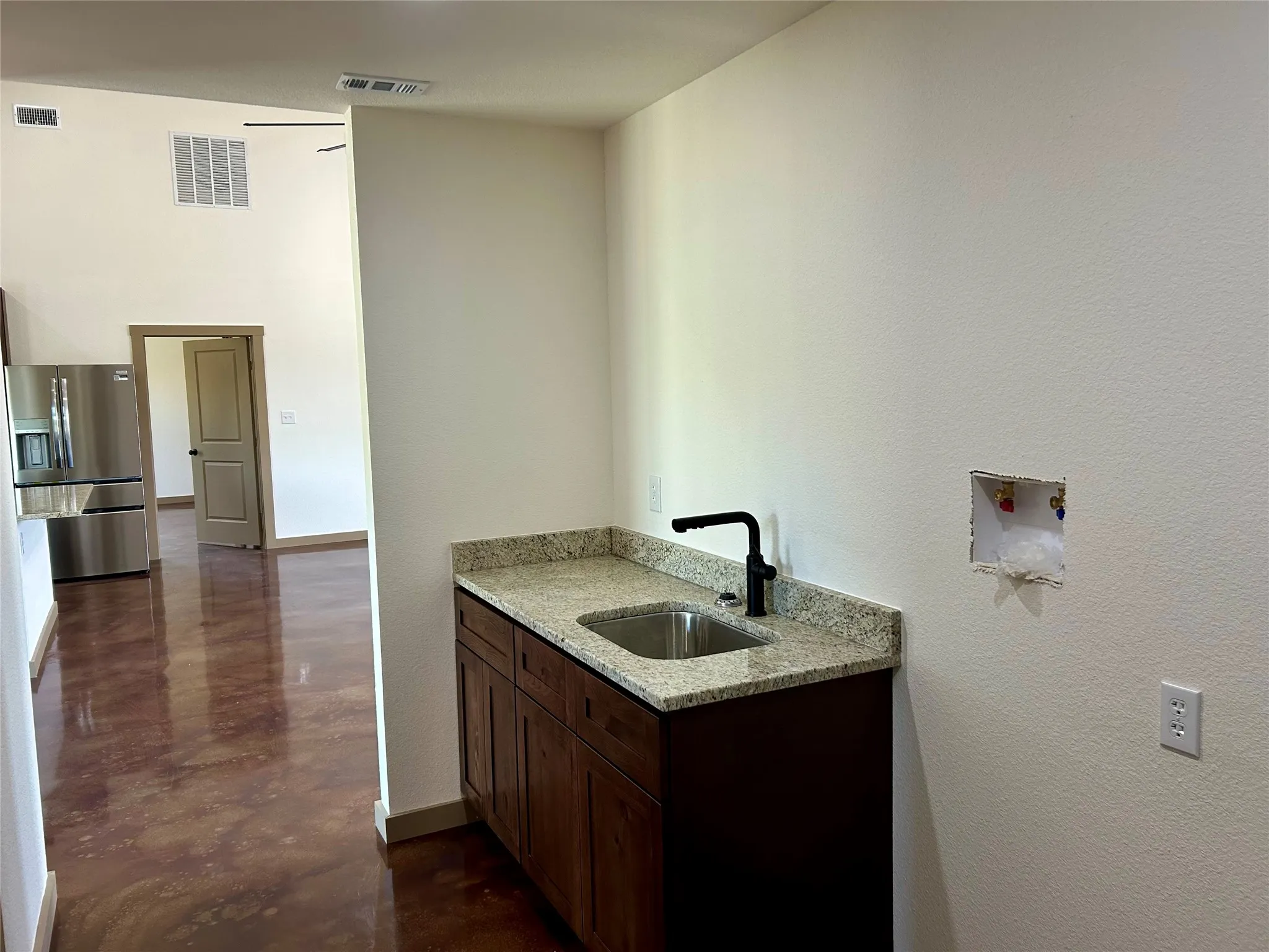 Washroom featuring a textured wall and a towering ceiling