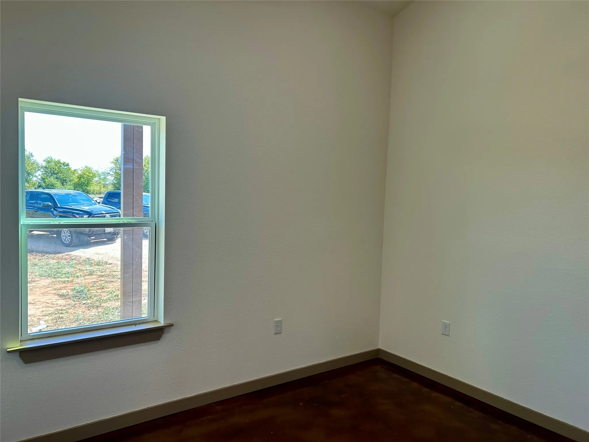 Spare room with baseboards and concrete floors