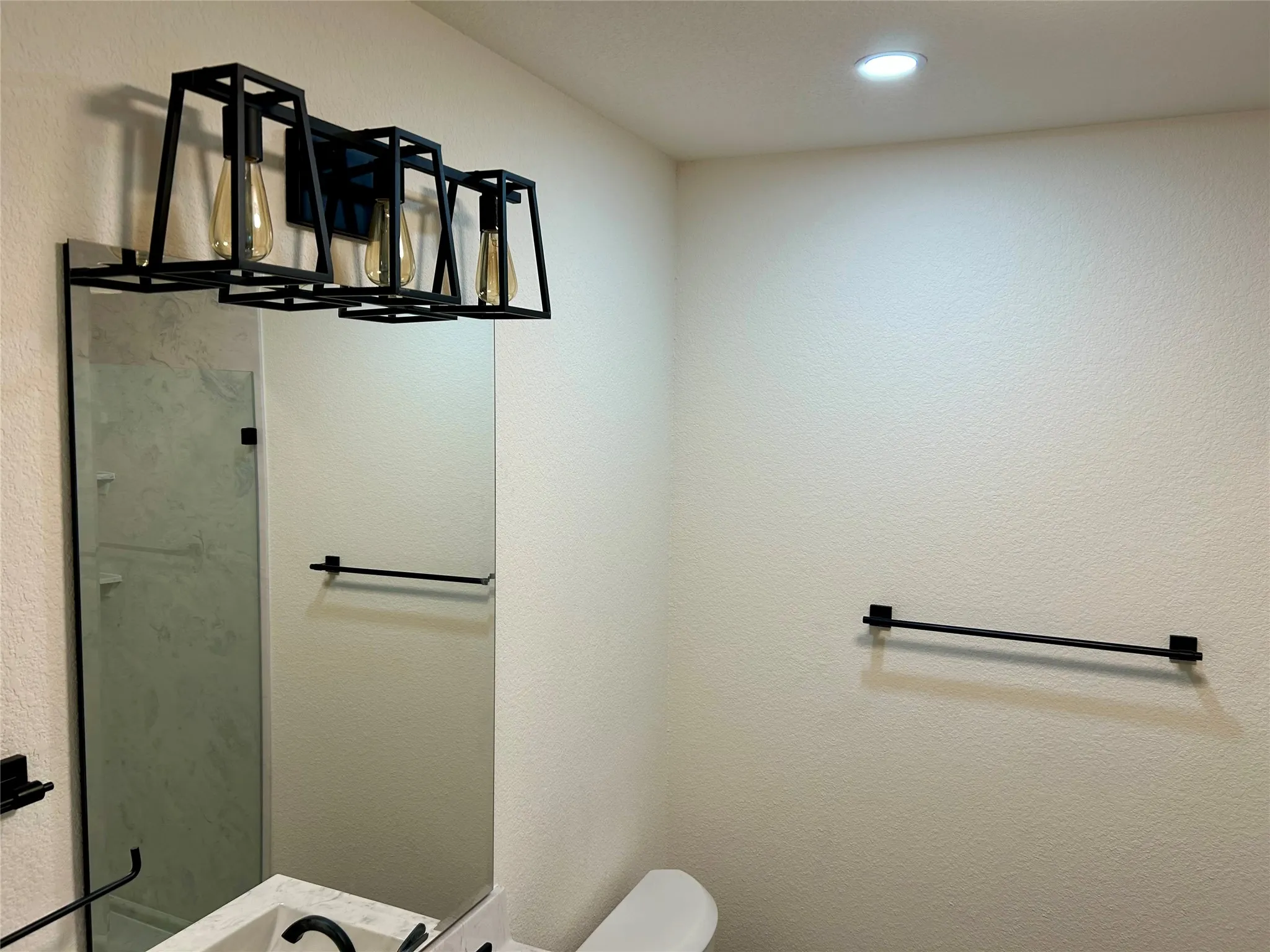 Bathroom with a textured wall and a shower