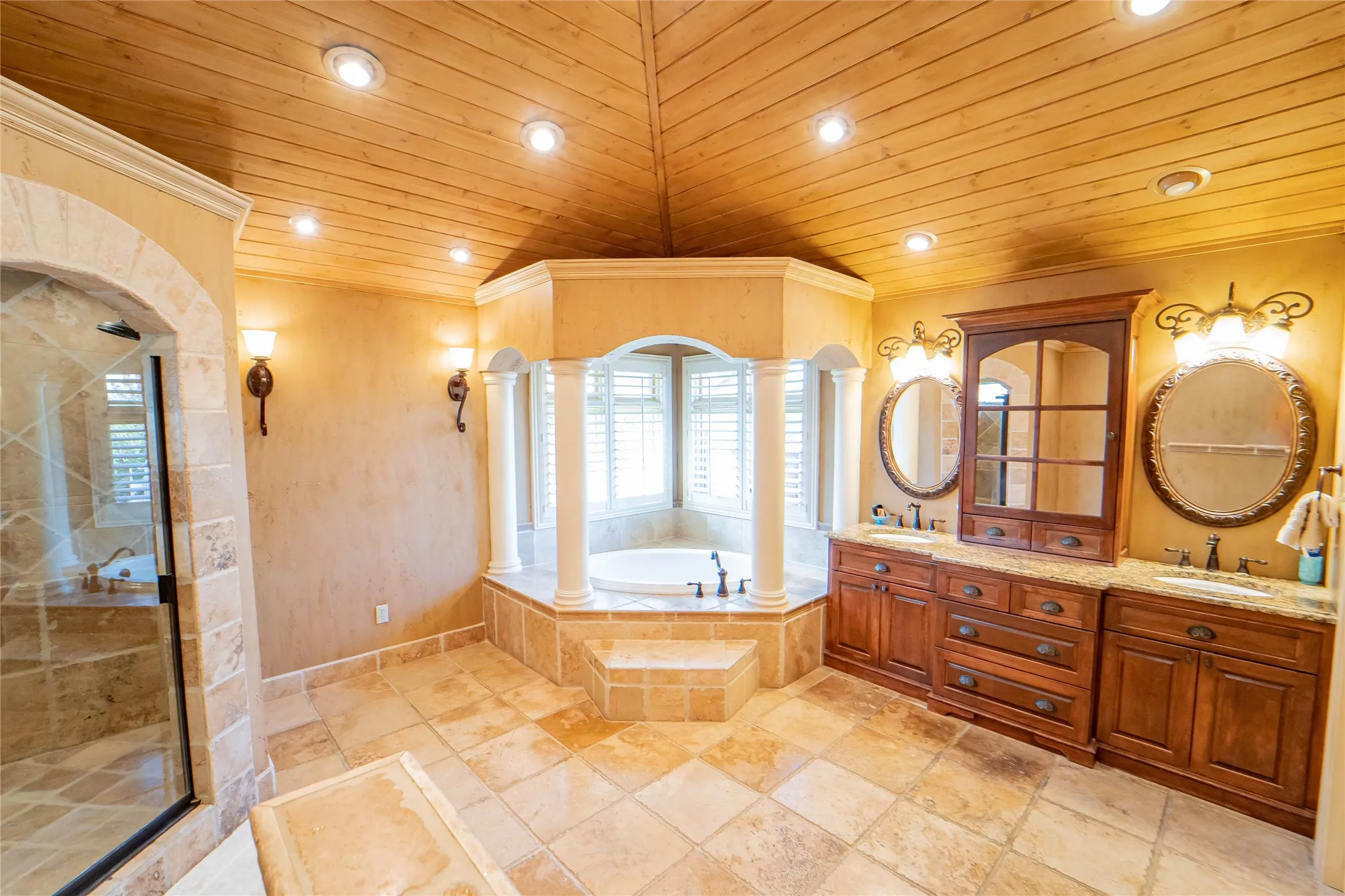 Luxurious en suite with dual sinks, ample cabinetry and a large walk-in rainfall shower.