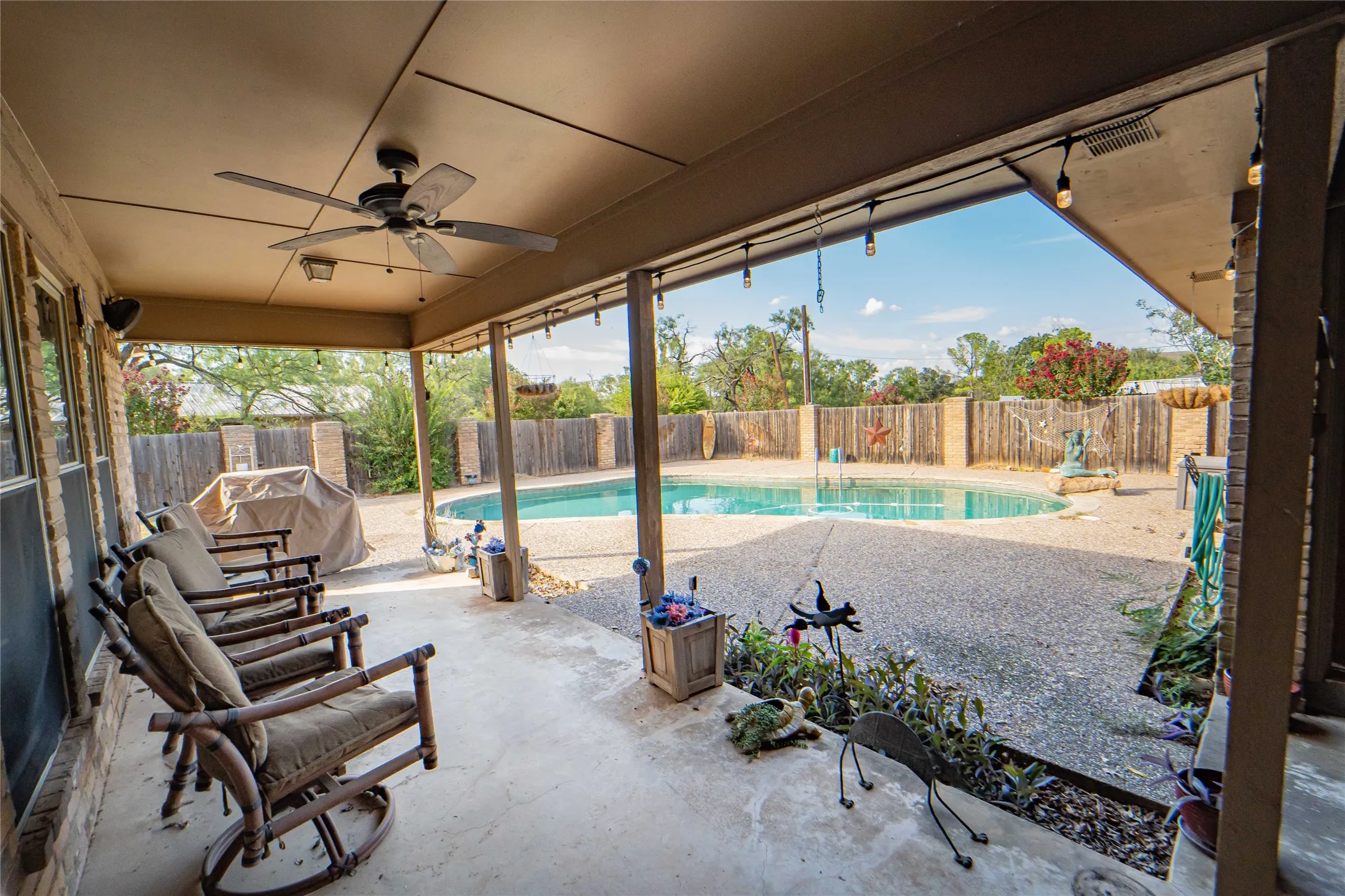 Covered patio located off of living and kitchen area offers pool side views and makes for a fantastic outdoor living arrangement!