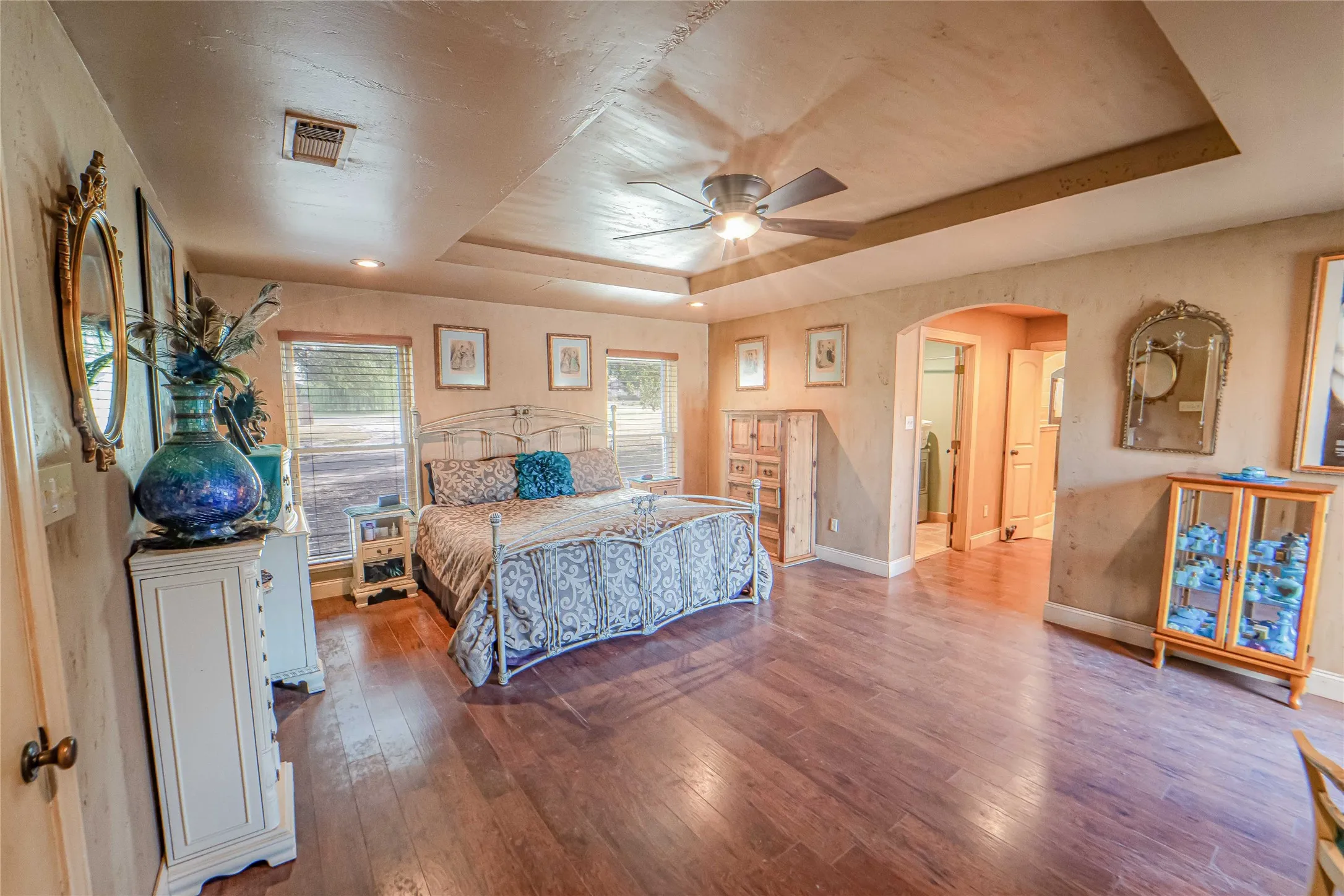 Luxury primary suite, tray ceiling, sitting area with patio/pool access door