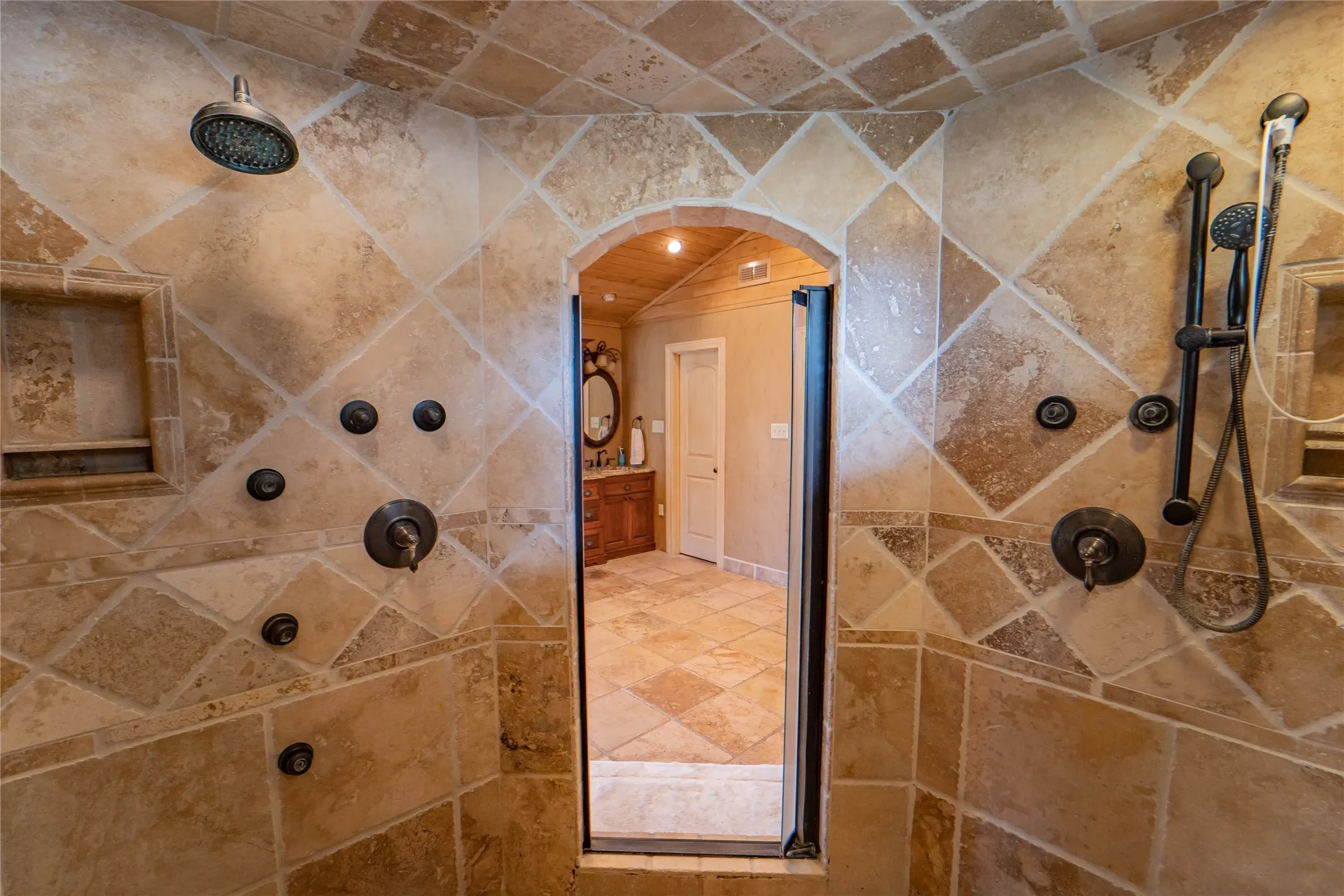 POV:  the spa-like primary en suite, walk in shower with custom tile and multiple spray heads.