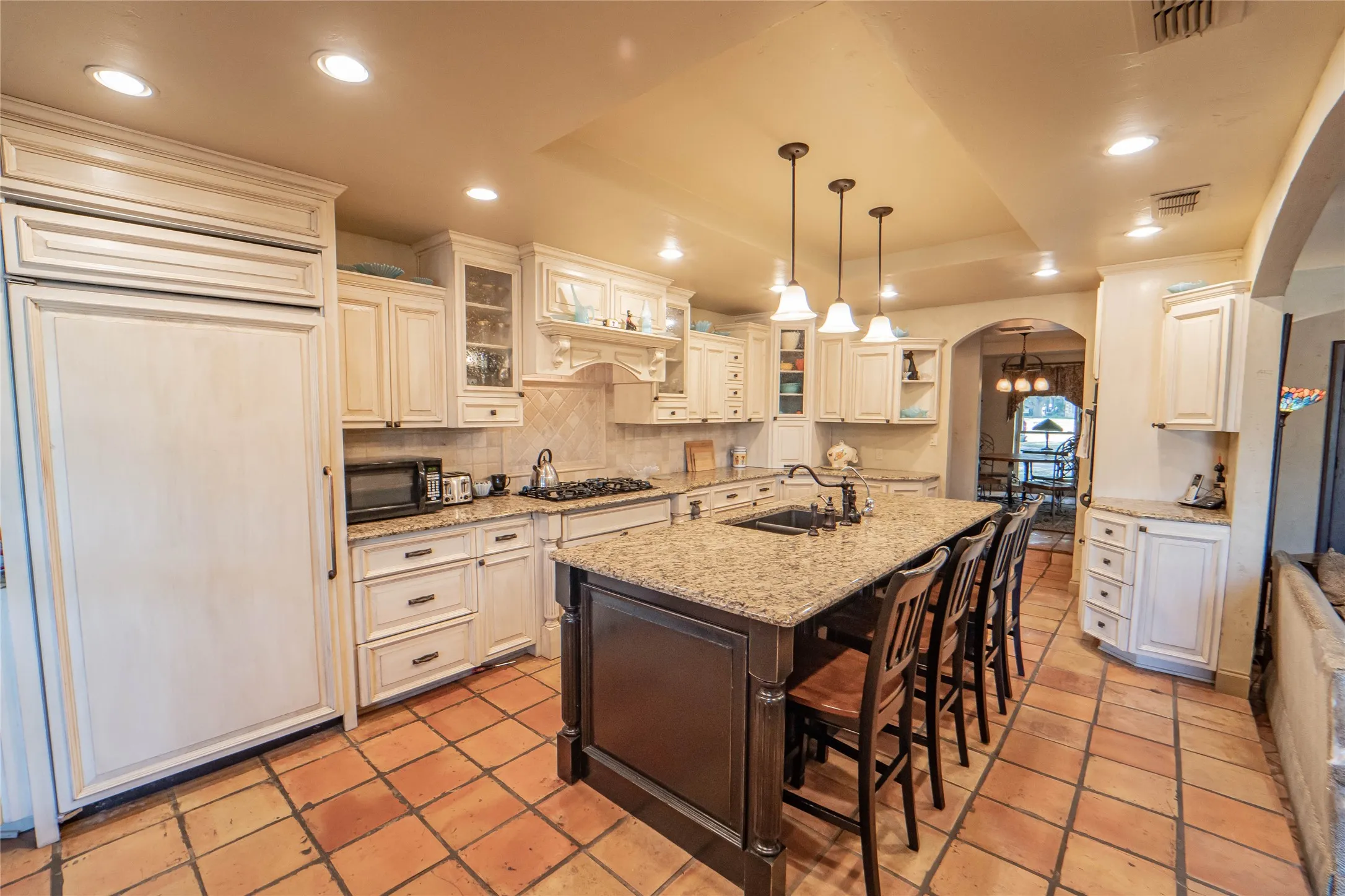 Spacious chef's kitchen with large island, granite countertops and custom cabinetry.