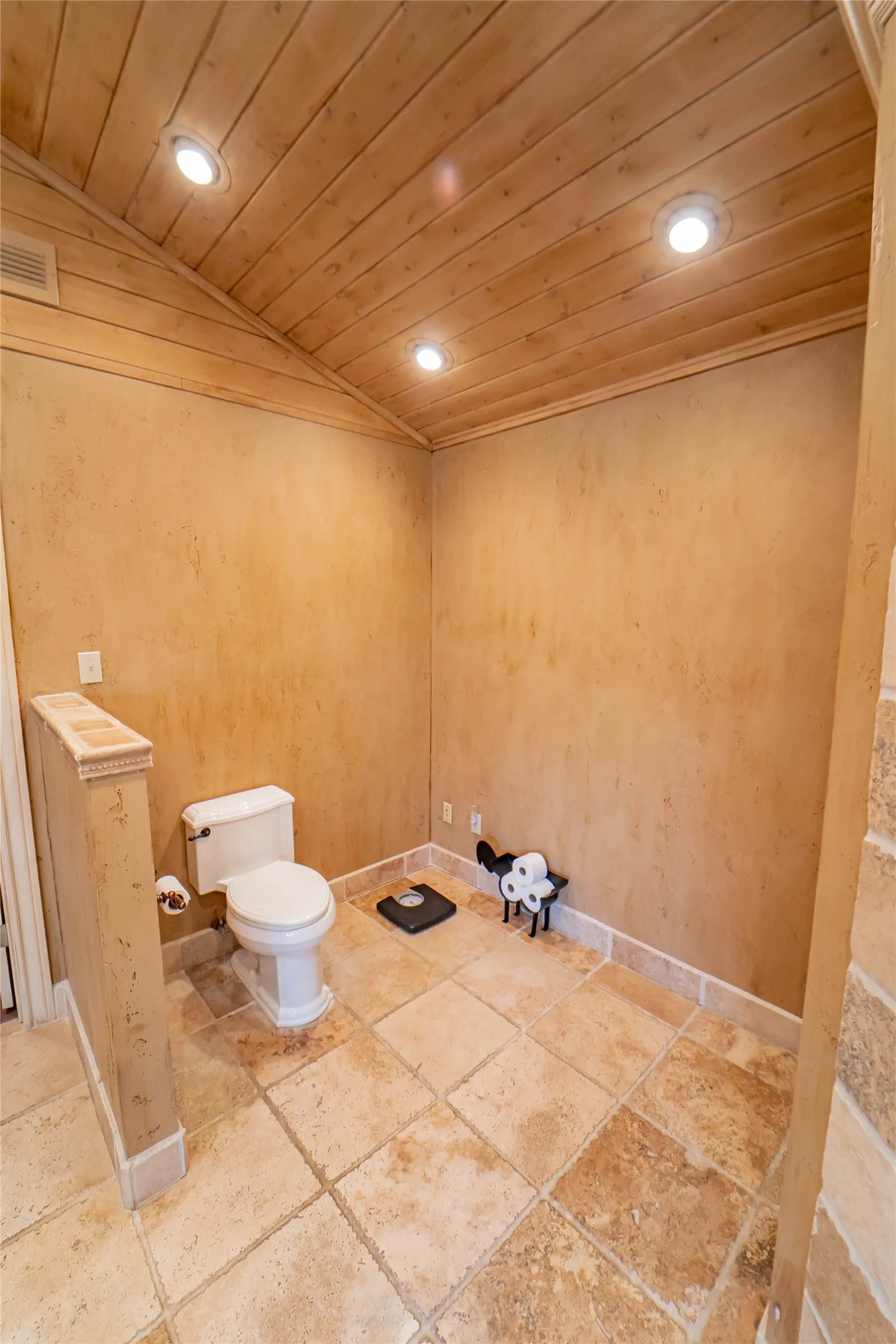 Spacious, dedicated water closet area with recessed lighting and warm wood-paneled ceiling.