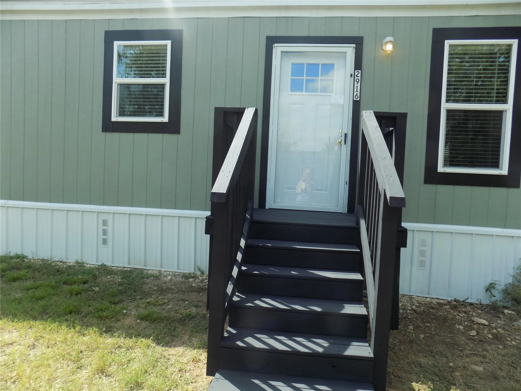 Front door with glass door and sturdy steps and rails, great color.