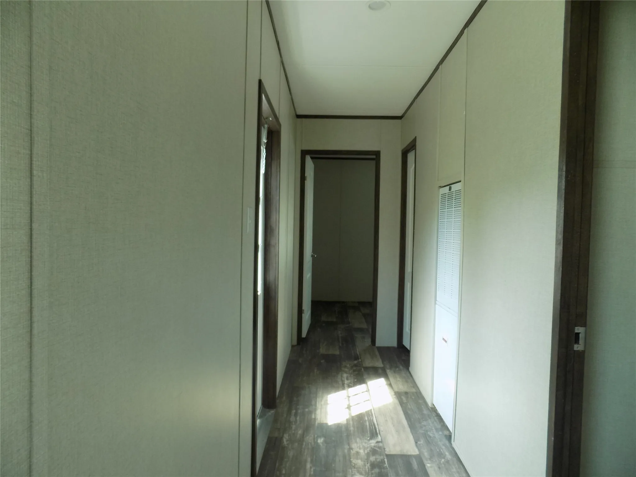 Hallway from living area leading to two bedrooms in the split bedroom arrangement.