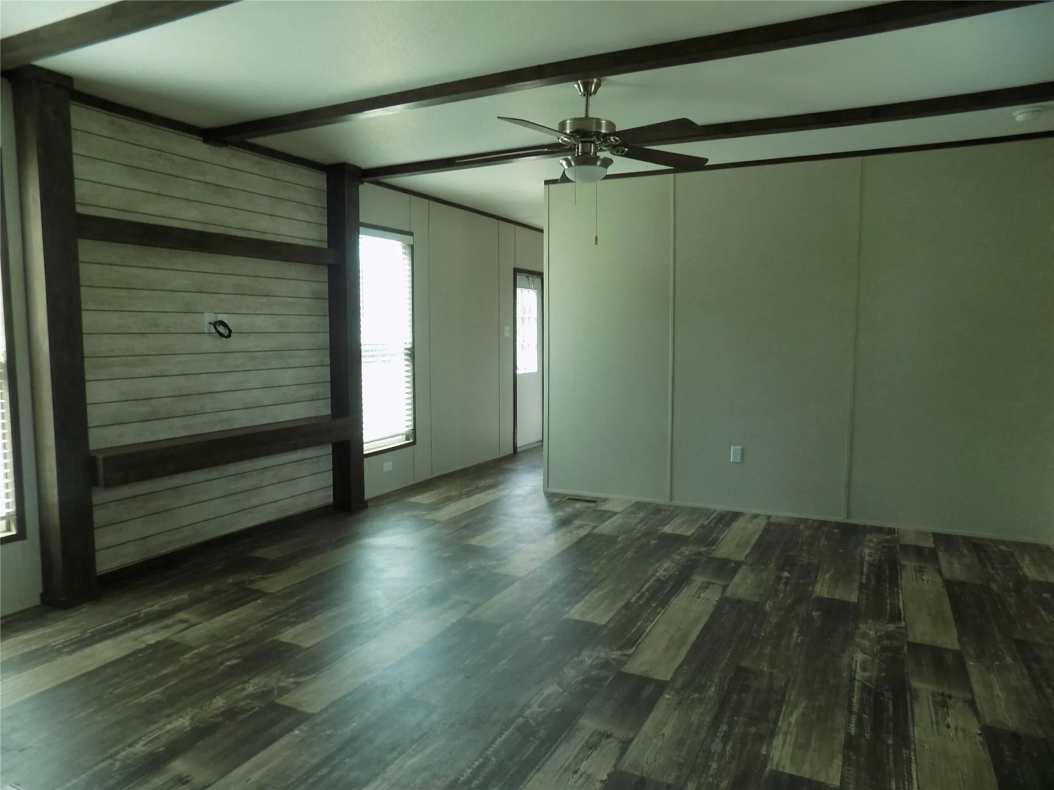 Open living area with flat TV space and shelf.  Lovely open beams for accent.