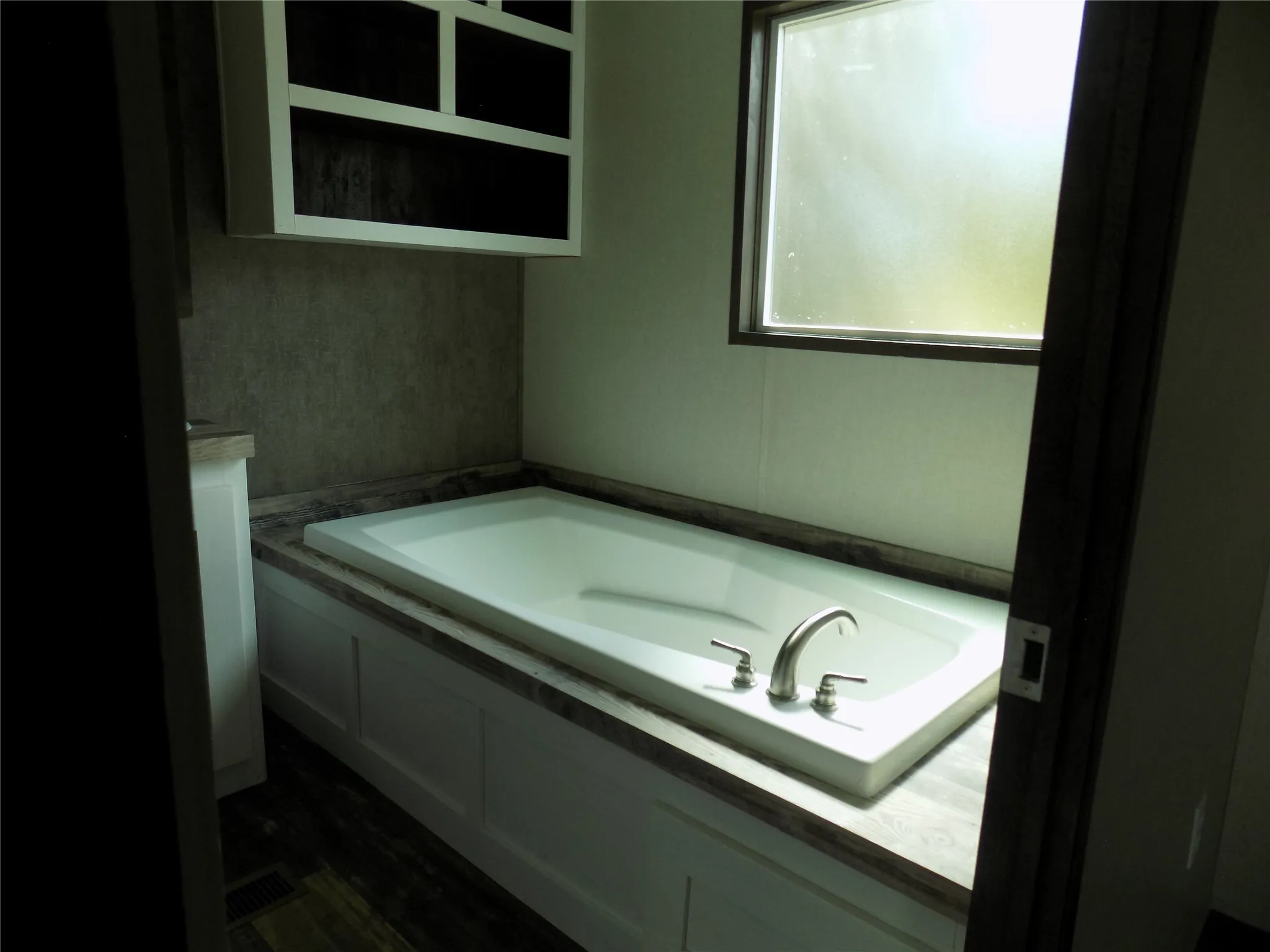Lovely garden tub with extra shelfing in primary bathroom.