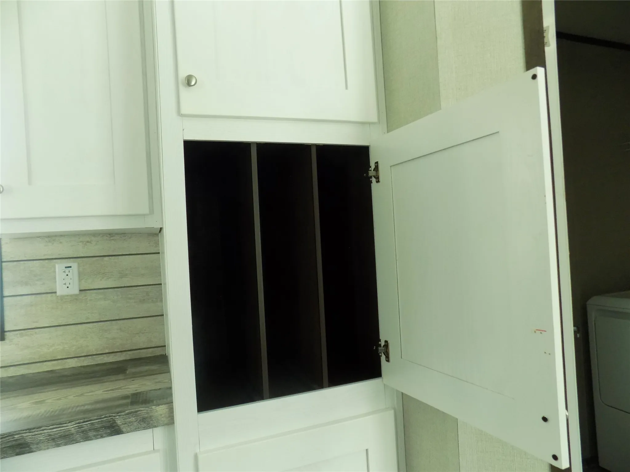 A special cabinet built in the kitchen area for cookie sheets, pizza pans, and other special cooking ware.