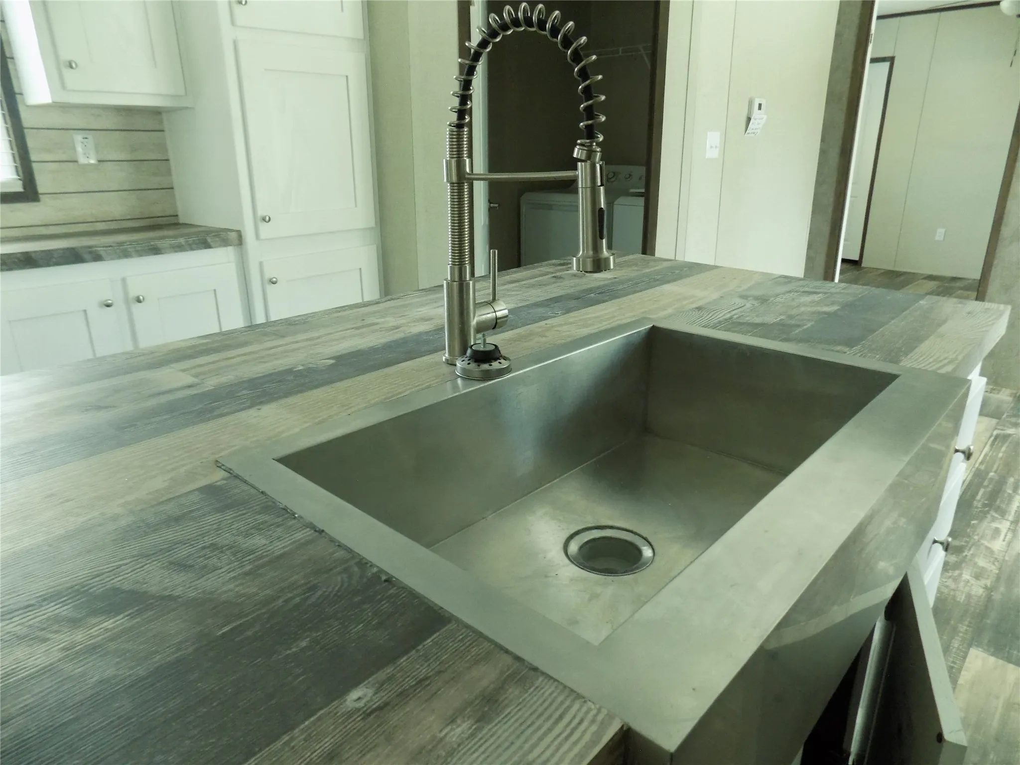 Wonderful farm sink with great faucet on the kitchen isle, with spacious counter tops to work on.