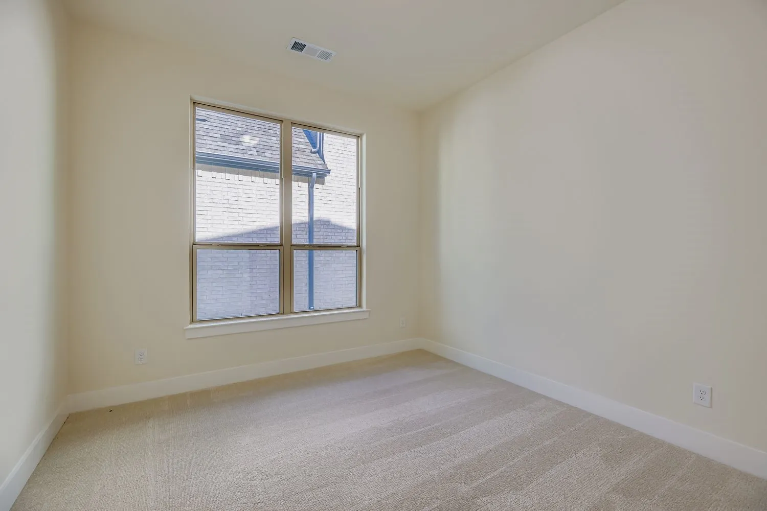 Spare room featuring light colored carpet and baseboards