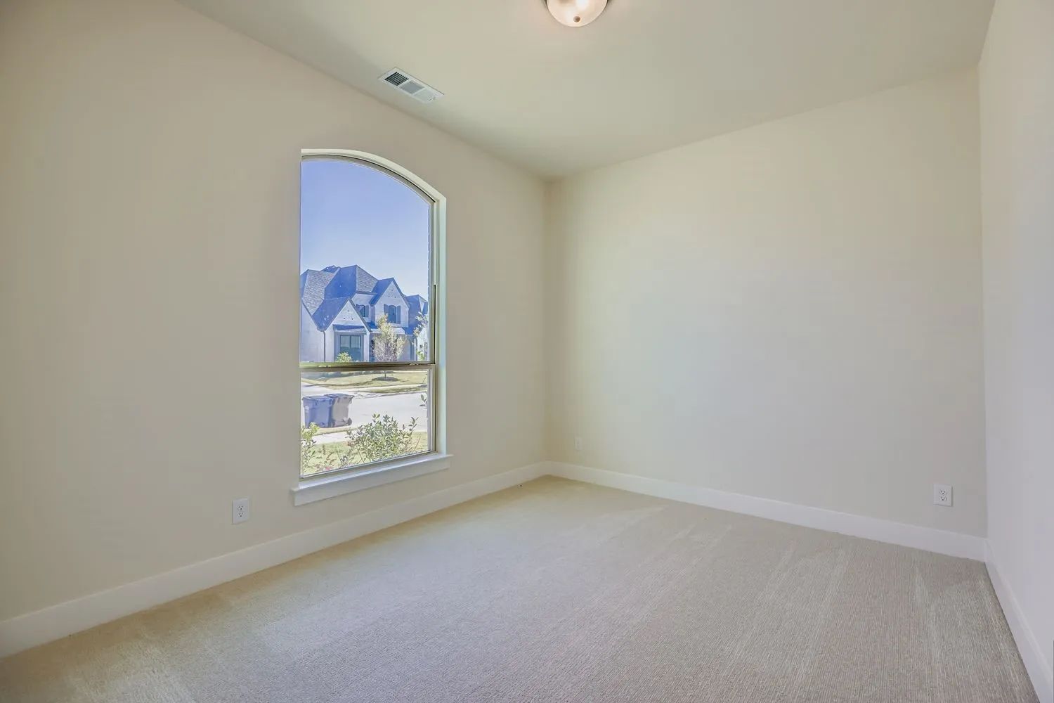 Unfurnished room featuring light carpet and baseboards
