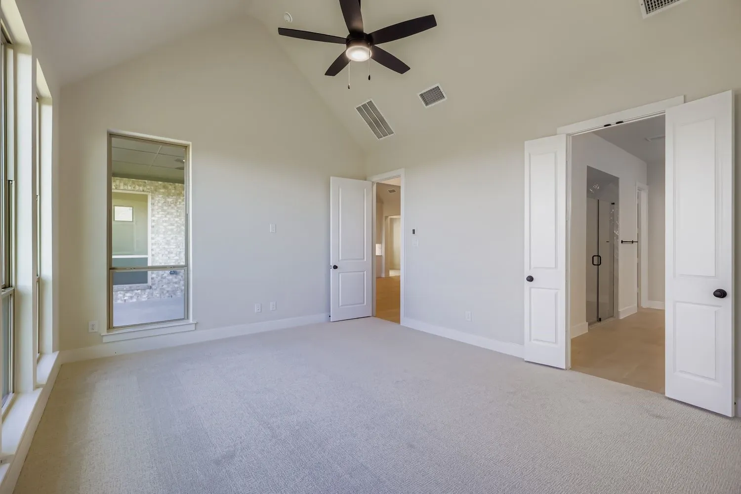 Unfurnished bedroom with light carpet, high vaulted ceiling, and ceiling fan