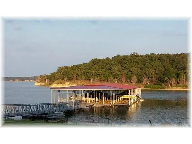 Dock area featuring a water view, a view of trees, and boat lift